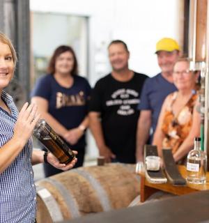 a woman holding a bottle of wine with a group of people