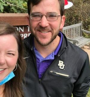 a man and a woman standing next to a bench