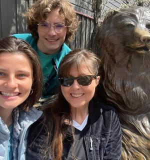 two women and a bronze statue of a bear