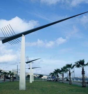 socha větrné turbíny v parku s palmami