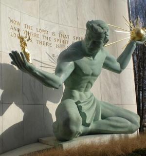 una estàtua d'un home que sosté una estrella davant d'un edifici