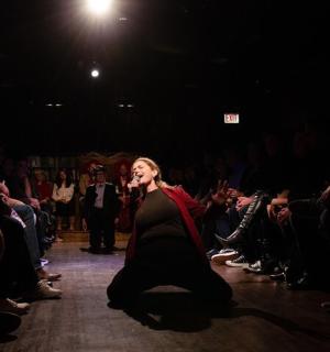 a woman walking down a runway in front of a crowd