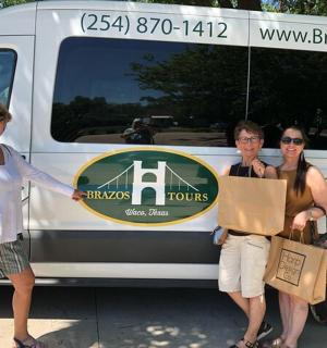 three women standing in front of a food truck