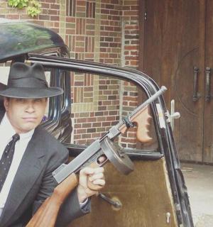 a man in a hat holding a gun in a car