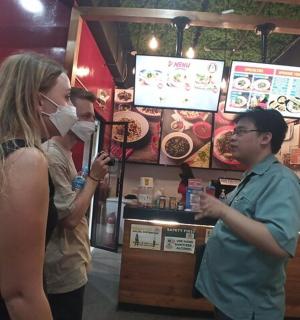 一名男子和一名女子站在一家食品店前