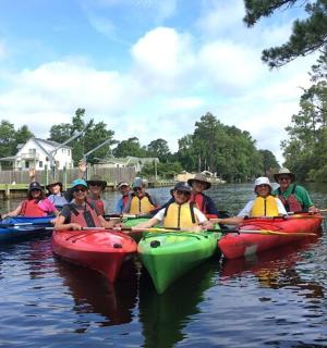 skupina lidí v kajacích na řece