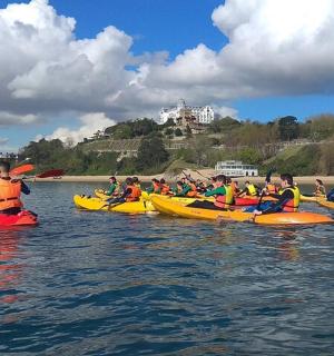 un grup de persones en caiacs a l'aigua