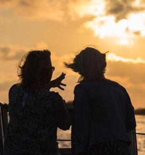 两个女人坐在船上看日落