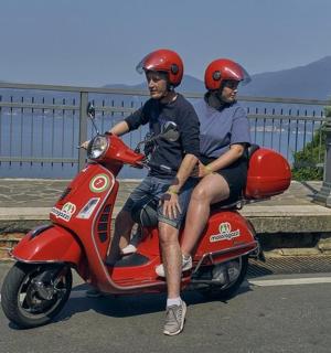 两名戴着头盔的男子坐在一辆红色摩托车上