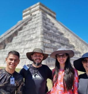 a group of people standing in front of a pyramid
