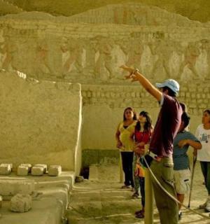 a group of people standing in front of a stone wall