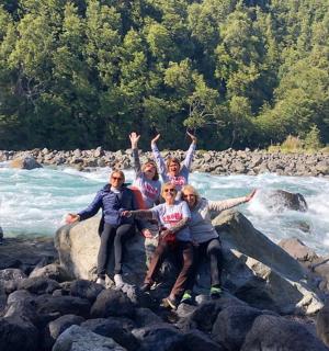 eine Gruppe von Menschen steht auf Felsen an einem Fluss