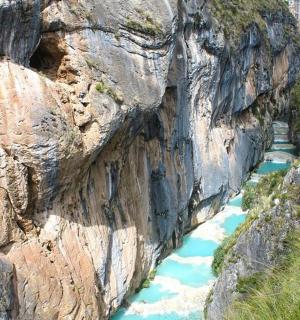 a river cuts through a rocky mountain cliff