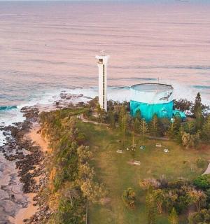 an aerial view of a lighthouse on an island in the ocean