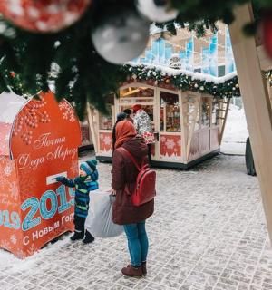 a woman and a child looking at a christmas market