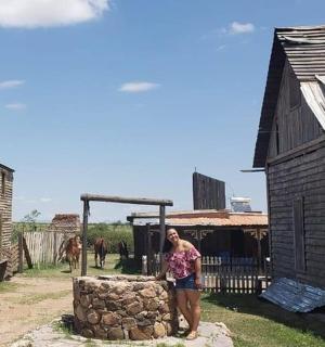 a woman standing next to a wooden building