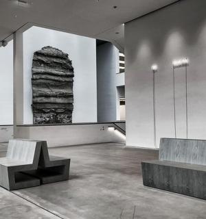 ein Raum mit zwei Bänken und einem Stein an der Wand