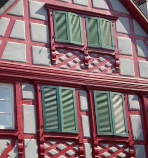 a red and white building with green shuttered windows