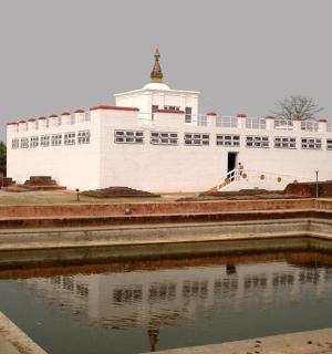 a large white building in front of a pool of water
