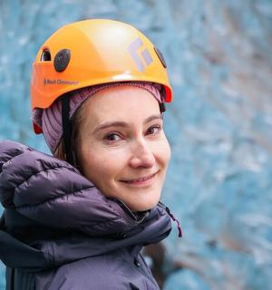 一名戴着橙色头盔的女子站在墙前