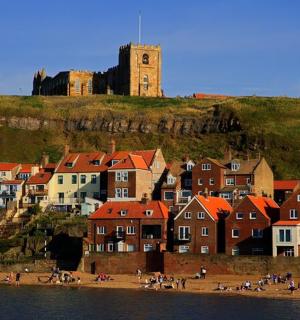 a group of houses on a hill with a clock tower