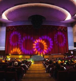 a large auditorium with a stage with purple lights
