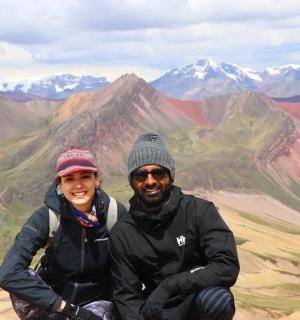 a man and woman sitting on top of a mountain