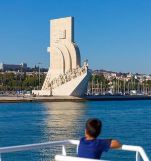 一个男孩在水中的船上，船上有一座纪念碑