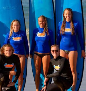 a group of people standing on the beach with surfboards