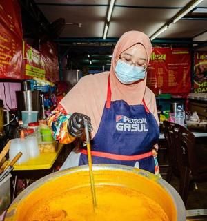 一名戴着口罩的人正在搅拌一大碗食物