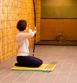 一位手持扫帚坐在垫子上的女人