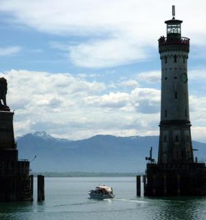 a boat in the water next to a lighthouse