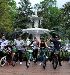 a group of people on bikes in front of a fountain