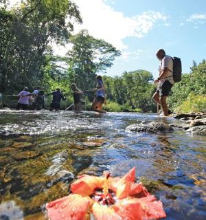 skupina lidí jdoucích přes řeku