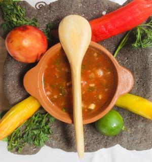 a bowl of soup on a plate with vegetables