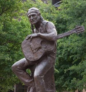 socha muže hrajícího na kytaru