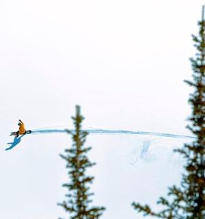 a man flying through the air while riding a snowboard