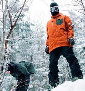two men standing in the snow in the woods