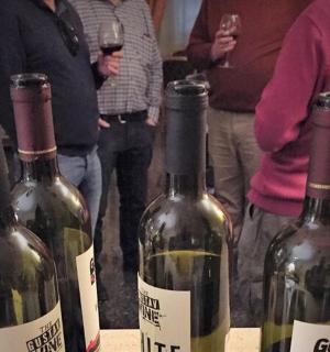 一群人围着三瓶酒站着