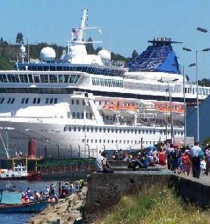 ein Kreuzfahrtschiff, das mit einer Menschenmenge an einem Dock angedockt ist