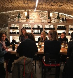 一群人坐在酒窖的一张桌子旁