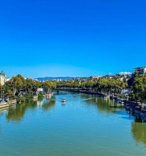 a river with boats in the middle of a city