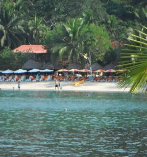 şemsiyeli ve plajda insanların olduğu bir plaj