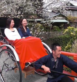 一名男子用人力车拉着一名女子