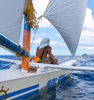 一名男子坐在海上的帆船上