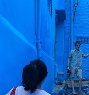 a young boy standing in a blue alley