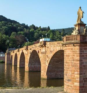 a statue on a brick bridge over a river