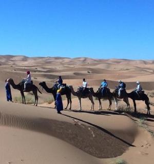 a group of people riding horses in the desert