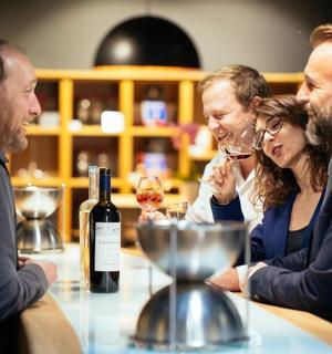 一群人坐在桌边，手里拿着酒杯