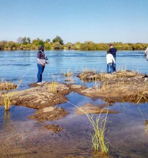 一群人站在水中的岩石上